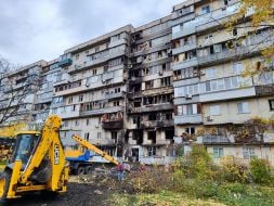 Полуразрушенный и обгоревший фасад жилого дома после ночной атаки дронами в Деснянском районе Киева