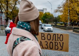 Женщина держит плакат с надписью "Волю Азову"