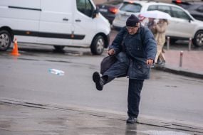 An elderly man walks down the street in Kyiv