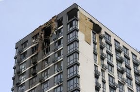 Напівзруйнований та обгорілий фасад житлового будинку  після нічної атаки російської федерації в Подільському районі  міста Києва