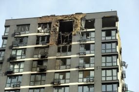 Напівзруйнований та обгорілий фасад житлового будинку  після нічної атаки російської федерації  в Подільському районі міста Києва