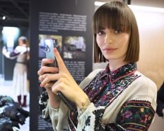 Young woman in embroidered dress holding mobile phone