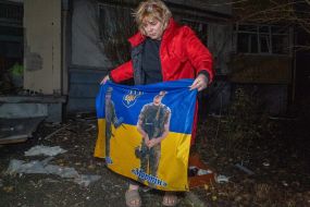 Женщина держит флаг Украины с изображенными на него военнослужащими после ночной атаки российских дронов в Харькове