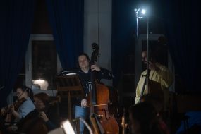 Музыканты Национального заслуженного академического симфонического оркестра Украины проводят репетицию в полумраке