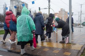 Пожилая женщина попрошайничает на улице в Киеве