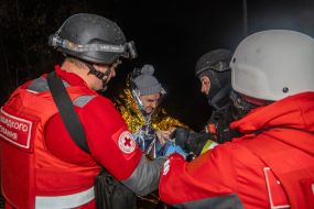 Медики Червоного хреста допомагають чоловіку, який постраждав в наслідок повітряного нальоту дронів, у Харкові