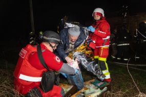 Медики Червоного хреста допомагають чоловіку, який постраждав в наслідок повітряного нальоту дронів, у Харкові