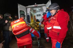 Медики Червоного хреста вантажать у карету швидкої допомоги тіло жінки, яка загинула в наслідок повітряного нальоту російських безпілотників у Харкові