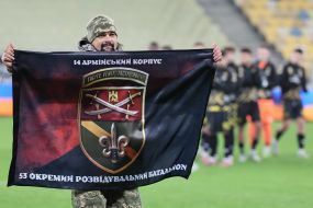 Військовослужбовець тримає прапор 53-го окремого розвідувального батальйону