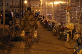 A serviceman with a lamp with the Bethlehem Fire near the Wall of Remembrance on Mikhailivska Square in Kyiv