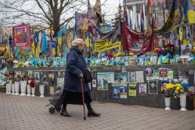 A woman walks by flags in memory of the fallen defenders of Ukraine