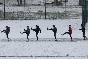 A youth football team trains on a snowy field in Kyiv