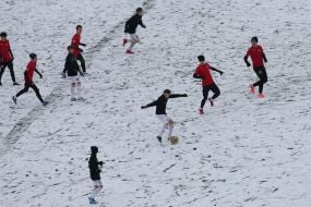 A youth football team trains on a snowy field in Kyiv