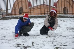 Teenagers build a snowman in a park in Kyiv