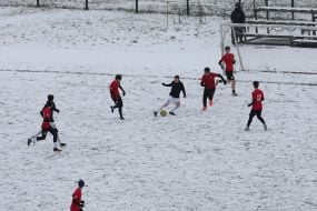 A youth football team trains on a snowy field in Kyiv