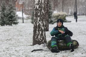 A boy with a tube on a snowy street in Kyiv