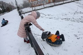 A boy with a tube on a snowy street in Kyiv