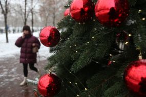Snowflakes on the branches of a Christmas tree decorated with toys, on a street in Kiev