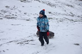 A boy with a tube on a snowy street in Kyiv