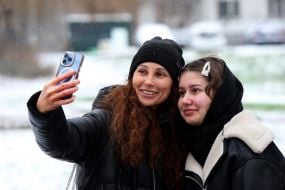 Женщина с девушкой делать селфи на фоне заснеженной улицы в Киеве