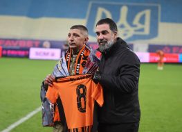 A serviceman takes a photo with the Shakhtar coach