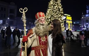 A man dressed as St. Nicholas stands near Lviv's main New Year's tree.