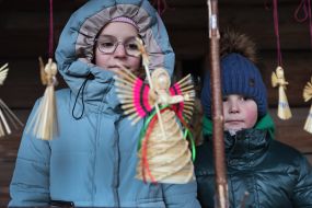 Дети рассматривают соломенного Рождественского ангела