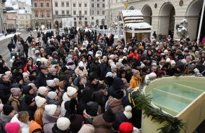 People collect holy water from a large reservoir on Rynok Square in Lviv