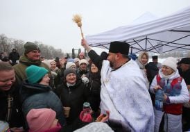 Священник кропить святою водою людей
