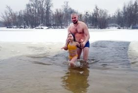 Девочка с отцом купаются в проруби