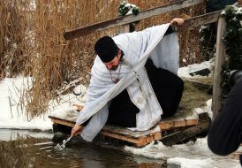 Священник освящает воду