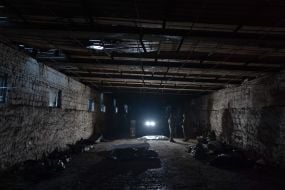 Volunteers of the search organization "Platsdarm" examine the remains of Ukrainian and Russian soldiers in the Donetsk region
