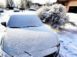 A parked car covered in snow on a street in Kiev