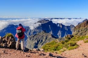 Турист оглядає краєвиди на вершині гори Піку-ду-Арейру