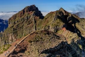 Туристи йдуть стежкою неподалік вершини гори Піку-ду-Арейру