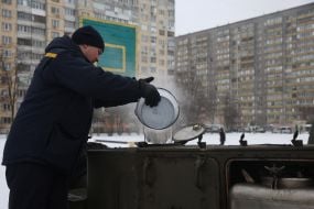 Employees of the State Emergency Service near a field kitchen in a tent camp