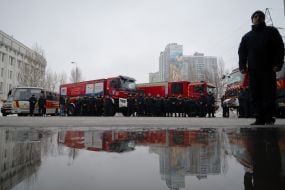 Сотрудники ГСЧС возле пожарных автомобилей