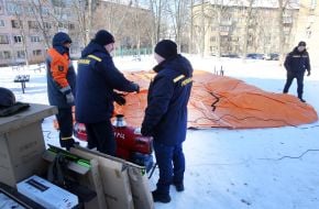 Rescuers set up a tent near a residential building damaged by Russian shelling
