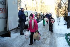 Residents carry out surviving items from the damaged house.