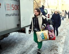 Residents carry out surviving items from the damaged house.