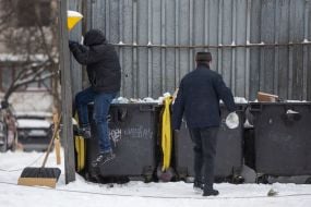 A municipal worker compacts garbage in a garbage container in Kyiv