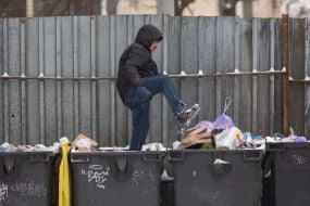 A municipal worker compacts garbage in a garbage container in Kyiv