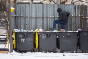 A municipal worker compacts garbage in a garbage container in Kyiv