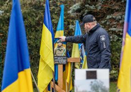 A man near the grave of a fallen Ukrainian defender on the Hill of Glory in Uzhhorod