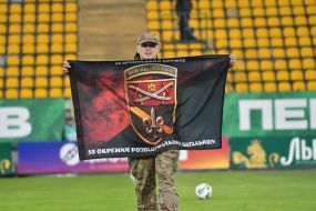 Female soldiers with military flag on field