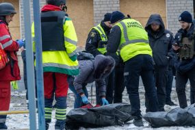 A woman identifies the body of a deceased person at the site of a Russian missile hitting a five-story apartment building in the Kyivskyi district of Kharkiv