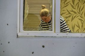 Выбитое в результате обстрела окно в жилом доме