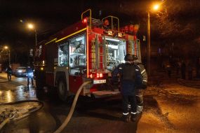 Пожарная машина возле дома и автомобилей, пострадавших в результате обстрела Харькова