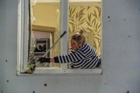 Выбитое в результате обстрела окно в жилом доме