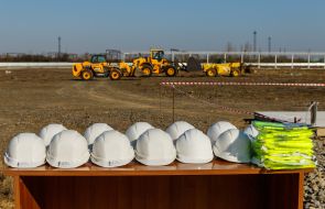 Защитные каски на столе на фоне строительной техники на территории предприятия ООО "БФ ЗАВОД"